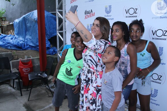 Preta Gil tira selfies com moradores do Complexo do Alemão