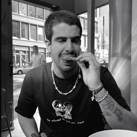 Foto mostra Enzo comendo no que parece ser uma mesa de bar