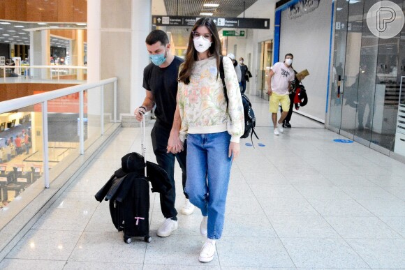 Camila Queiroz escolheu jeans, moletom e tênis para viagem com marido