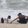 Luciano Huck ajuda Benício a cavar na areia da praia