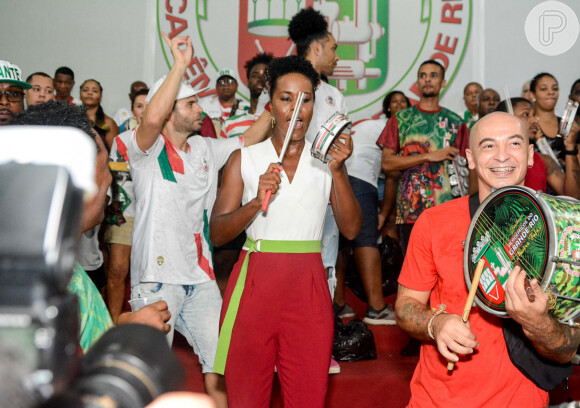 Carnaval 2022: Maju Coutinho, vestida comc calça social vermelha e usando cinto verde, também compareceu ao ensaio da Grande Rio
