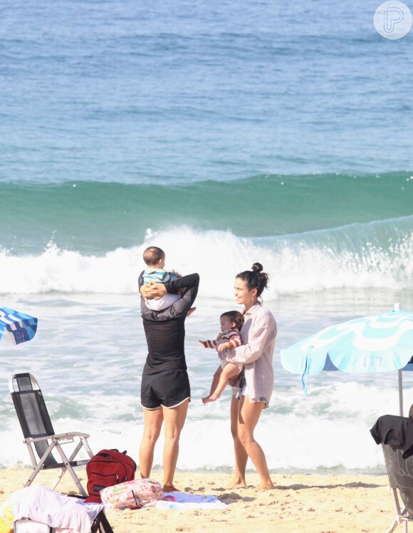Nanda Costa e Lan Lanh foram flagradas em uma praia do Rio de Janeiro com as gêmeas
