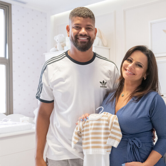 Viviane Araujo e o marido, Guilherme Militão, posam sorridentes no quarto de Joaquim