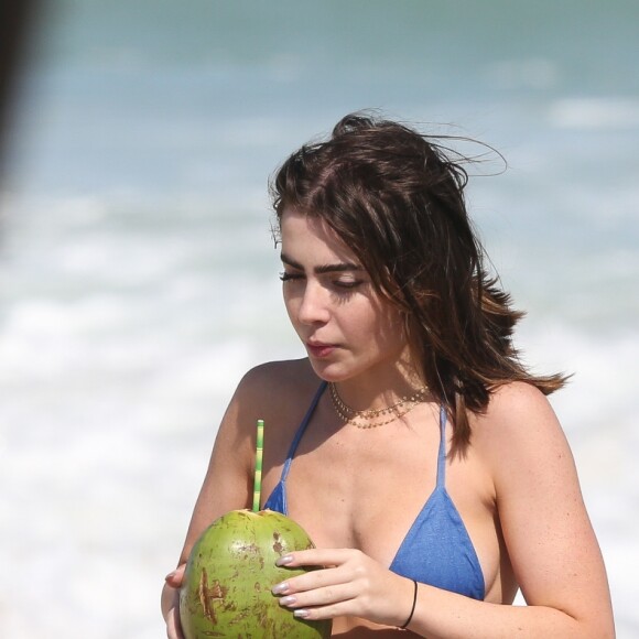 De biquíni, Jade Picon saboreou uma água de coco em dia de praia