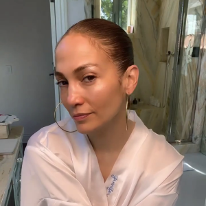 Jennifer Lopez, após a rotina de skin care. Para garantir o glow, ela finaliza com iluminador, brilho labial hidratante e máscara de cílios
