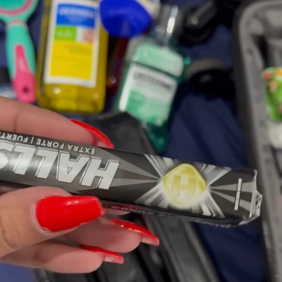 Dentro da mala, uma necessáire leva coisas como balas, desodorante e enxaguante bucal