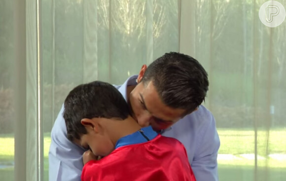 O papai Cristiano Ronaldo dá um beijo no filho ao chegar da escola