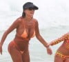 Deborah Secco elege biquíni laranja neon fio-dental para curtir praia com a filha Maria Flor
