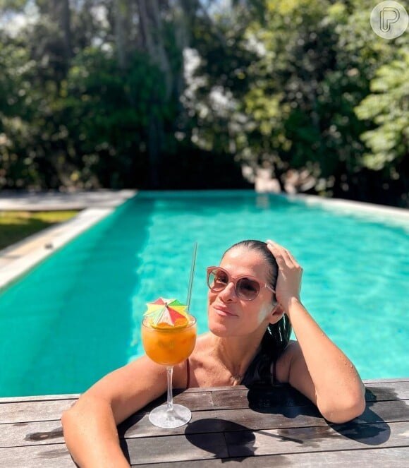 Ingrid Guimarães posou radiante na beira de uma piscina com um bom drink