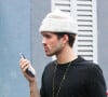 João Guilherme apareceu falando ao celular usando uma touca branca, blusa preta, calça alfaiataria xadrez e botas de cowboy no Rio