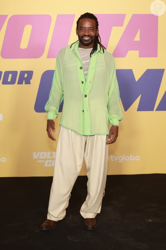 O ator Fabrício Boliveira, no lançamento de 'Volta por Cima', usou  calça nessa pegada mais larga off white, blusa verde e sapato social.