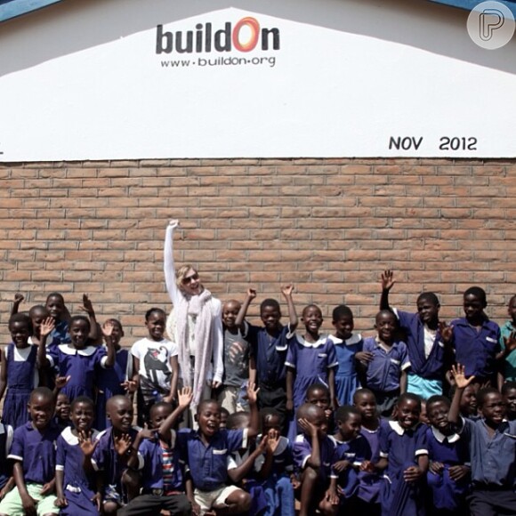 Madonna posa em frente a uma das 10 escolas que construiu no Malawi rebatendo críticas da presidente do país, em 11 de abril de 2013