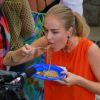 Angélica come yakisoba em prato de plástico durante gravação do programa 'Estrelas'