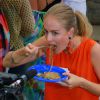 Angélica come yakisoba em prato de plástico durante gravação do programa 'Estrelas'