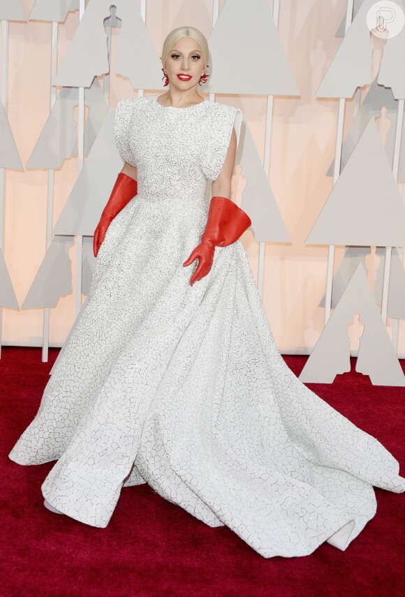 Lady Gaga, uma das atrações musicais da noite, apostou em um look branco do estilista Azzedine Alaïa e compôs o look com luvas vermelhas, causando frisson no red carpet
