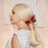 Lady Gaga usou cabelos presos e usou um arranjo na cor das luvas