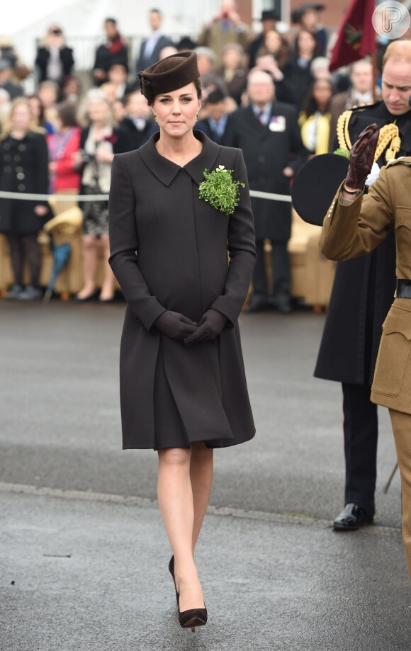Para o evento desta terça-feira, 17 de março de 2015, Kate Middleton escolheu um casaco marrom-escuro larguinho, da grife Catherine Walker, chapéu Lock & Co e sapatos de camurça da marca Emmy London
