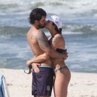 Juliano Cazarré namora a mulher e brinca com o filho na praia da Barra, no Rio