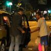 Alexandre Borges dá dinheiro a um engraxate antes de entrar no táxi