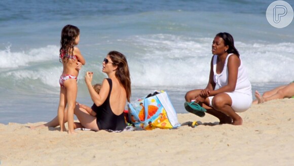 Cláudia Abreu apostou em um maiô preto, discreto, para o dia de praia