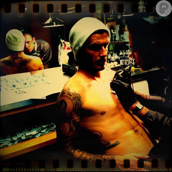 David Beckham em um estúdio de tatuagem. À época, o atleta ainda não possuía as duas tatuagens no seu peitoral