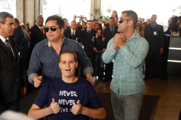 Pedro Leonardo deixa o hospital, conduzido pelo pai, Leonardo, à esquerda, e o primo e parceiro de trabalho, Thiago