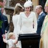 Príncipe George se apoia no carrinho para ver a irmãzinha, Charlotte, observado por Kate Middleton e príncipe William batizam