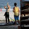 Cristiane Dias toma banho na mangueira da praia para se refrescar do calor