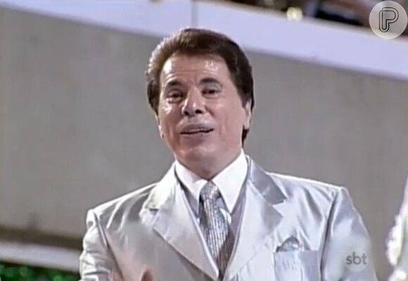 Latino ofereceu seu terno de casamento para Silvio Santos, que está atrás do modelo usado por ele no desfile da escola de samba Tradição, no Carnaval de 2001