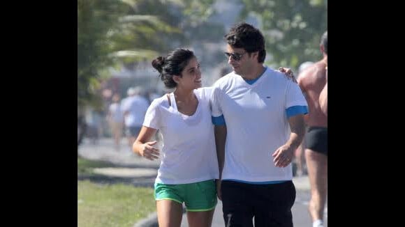 Vanessa Giácomo caminha com o marido, Giuseppe Dioguardi, na orla da praia