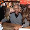 Gilberto Gil ganha beijo 'sanduíche' da filha, Preta Gil, e da amiga, Carolina Dieckmann, no lançamento do livro 'Gil Bem Perto', em 8 de julho de 2013