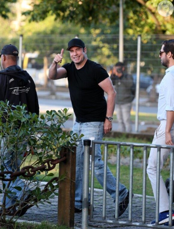 Simpático, John Travol acena para os paparazzi