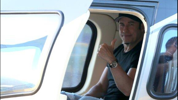John Travolta embarca em helicóptero no Rio e acena para os fotógrafos