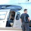 John Travolta acena de dentro do helicóptero