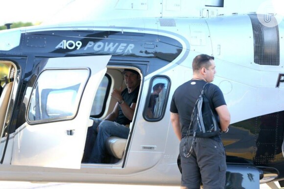 John Travolta acena de dentro do helicóptero