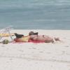Christine Fernandes pega sol deitada na praia