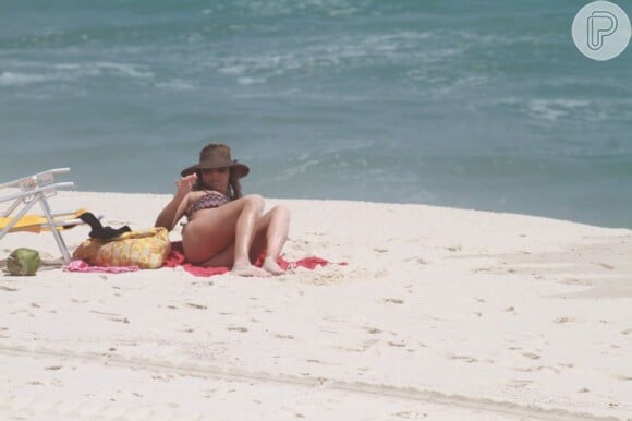 Christine Fernandes pega sol nas areias da praia