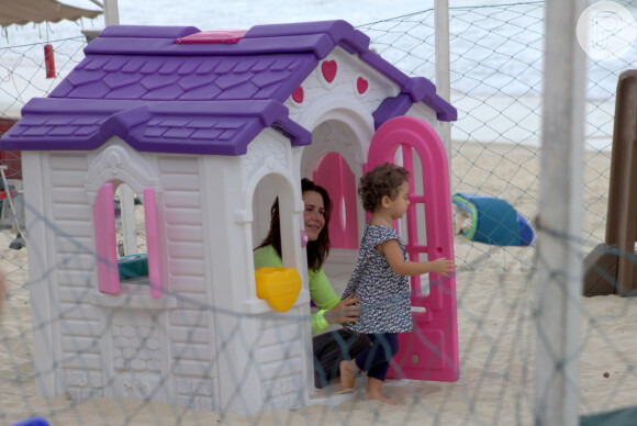 Guilhermina Guinle e a filha brincam em casinha na praia do Leblon