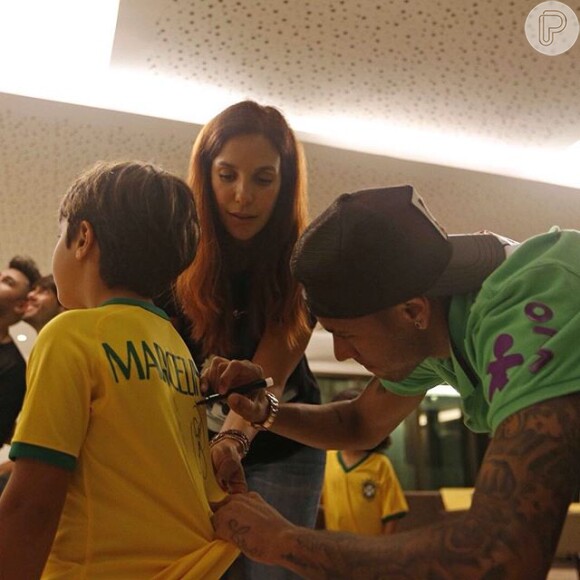 Ivete Sangalo ajuda Neymar a autografar a blusa de seu filho, Marcelo, de 6 anos