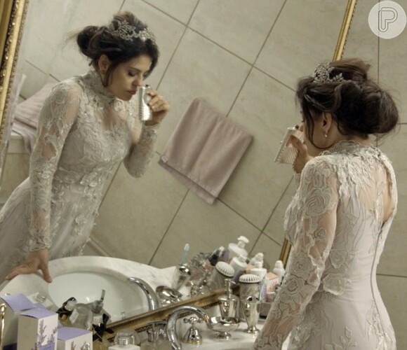 Nelita (Bárbara Paz) se tranca no banheiro e bebe perfume,  na novela 'A Regra do Jogo'