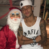Neymar comemorou a noite de Natal de uma maneira divertida. O jogador compartilhou uma foto sentado no colo do pai, seu Neymar, vestido de Papai Noel