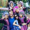 O ator faz pose com a namorada ao lado de crianças tailandesas