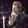 Bon Jovi chama Rosana Guedes para lhe dar o beijo que pediu no cartaz. A imagem é da câmera da fã