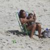 Mãe-coruja, ela brinca com o filhote na cadeira de praia