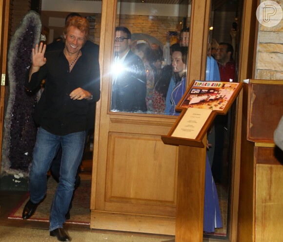 Jon Bon Jovi acena para os fotógrafos ao sair de restaurante em São Paulo neste sábado, 21 de setembro de 2013