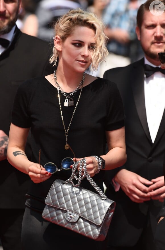 Kristen Stewart chegou ao evento com uma bolsa Chanel e com óculos escuros da marca Oliver Peoples The Row