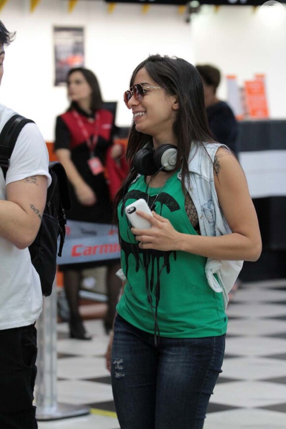 Anitta investiu em um look estiloso com regata bem cavada verde, o que acabou deixando parte de sua lingerie preta, de renda, à mostra, nesta quinta-feira, 24 de outubro de 2013, ao desembarcar no aeroporto de Congonhas, em São Paulo