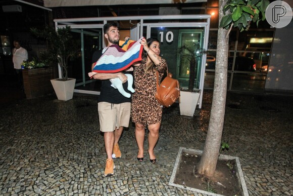 Preta Gil e o marido, Rodrigo Godoy, protegem Sol de Maria, neta da cantora, da chuva no Rio, nesta quinta-feira, 2 de junho de 2016, no Rio