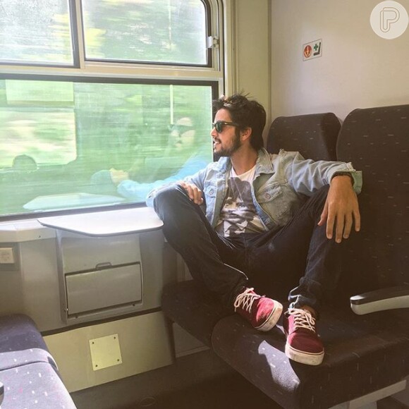 Curtindo férias, Rodrigo Simas observa a paisagem de Paris no interior de um trem