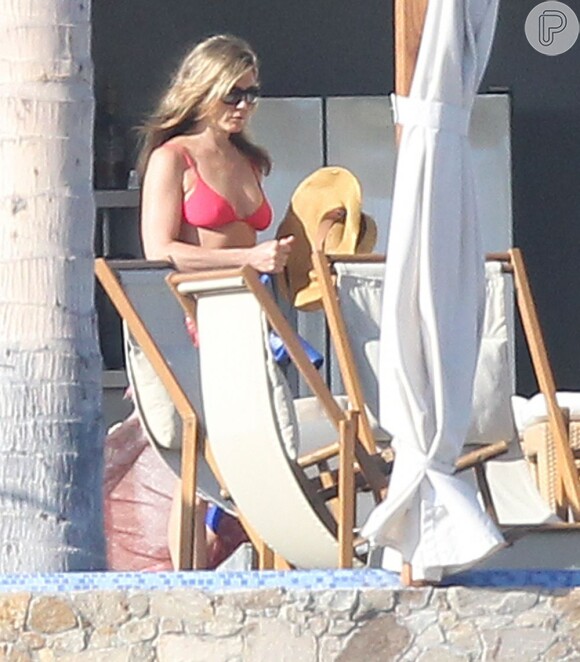 Jennifer Aniston escolhe um biquíni pink para aproveitar o dia de sol